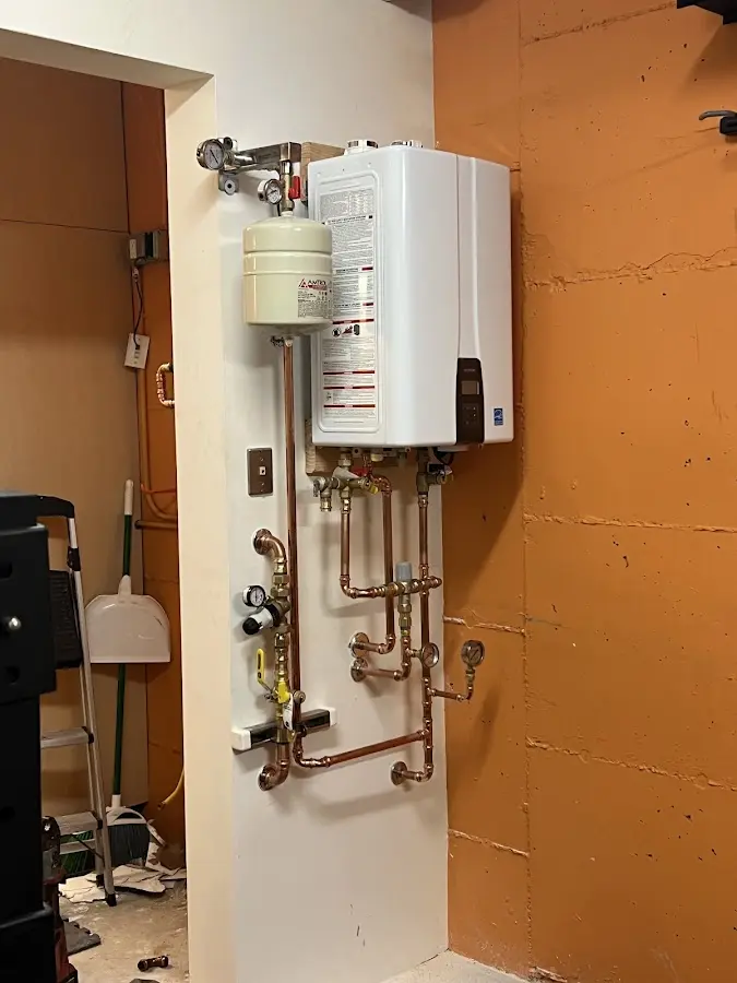 Plumbing technician inspecting water heater connections in Blackhawk